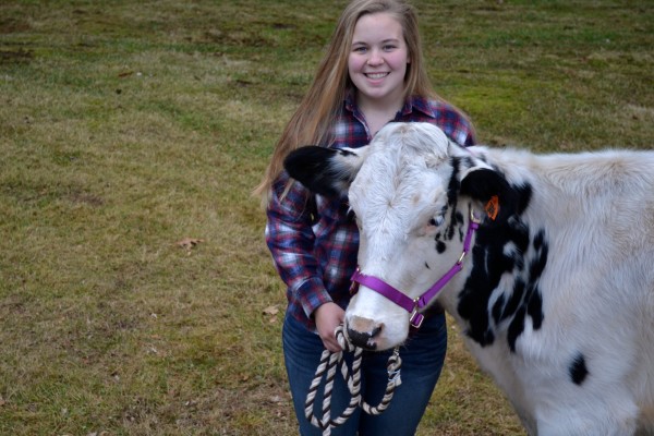 Kayla Visser poses with a cow on her farm