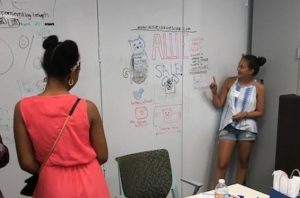 After using the whiteboard walls, a girl shows off her web concepts work